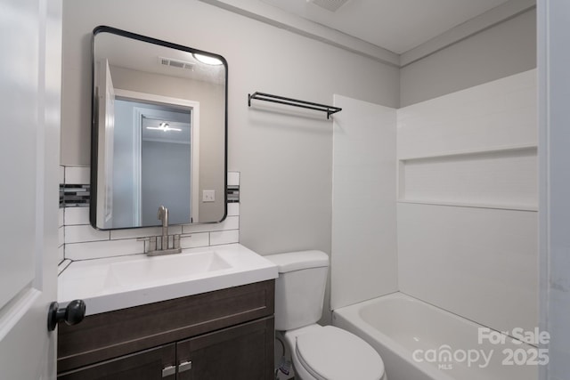 full bathroom featuring visible vents, decorative backsplash, toilet, vanity, and shower / washtub combination