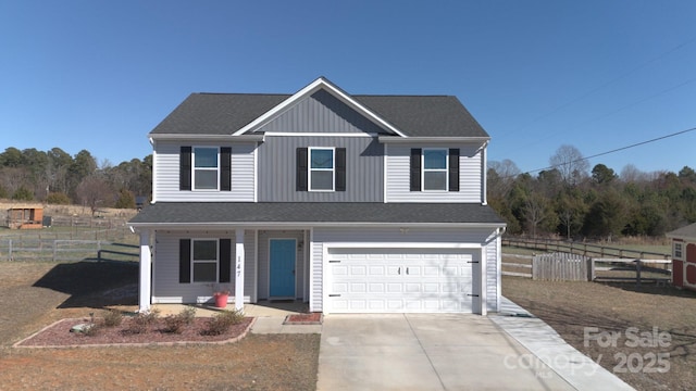 traditional-style home with a garage, fence, driveway, and a shingled roof