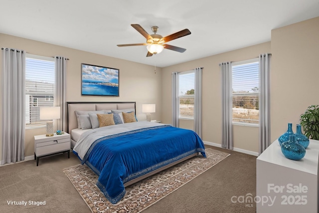 bedroom with dark colored carpet, a ceiling fan, and baseboards