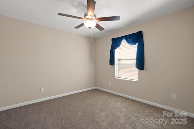 carpeted empty room featuring baseboards and a ceiling fan