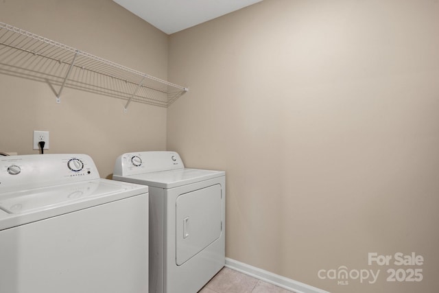 washroom with laundry area, light tile patterned floors, baseboards, and washer and clothes dryer