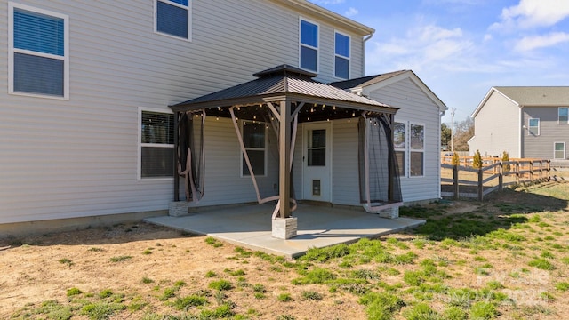 rear view of property with fence and a patio