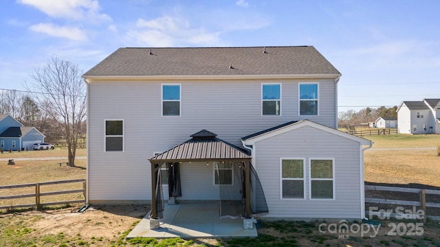 rear view of property with a gazebo, roof with shingles, a patio area, and fence