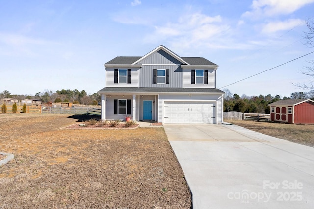 view of front facade featuring a garage, fence, concrete driveway, a storage unit, and board and batten siding