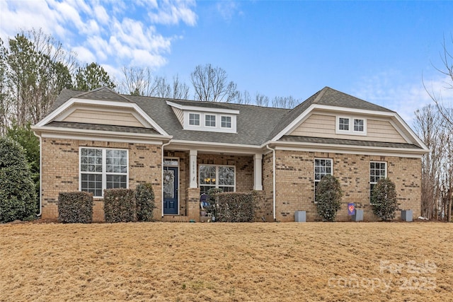 view of front of house with brick siding and roof with shingles