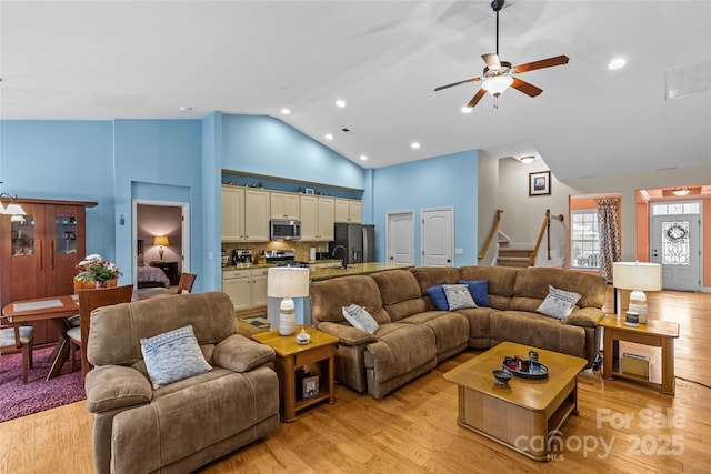 living area with light wood-style floors, visible vents, and stairway