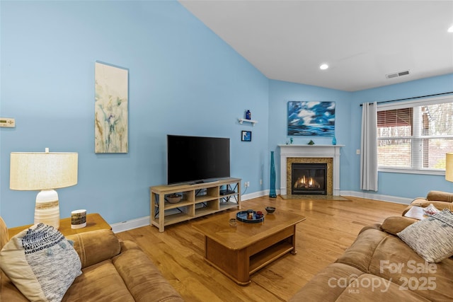 living area with wood finished floors, visible vents, and baseboards