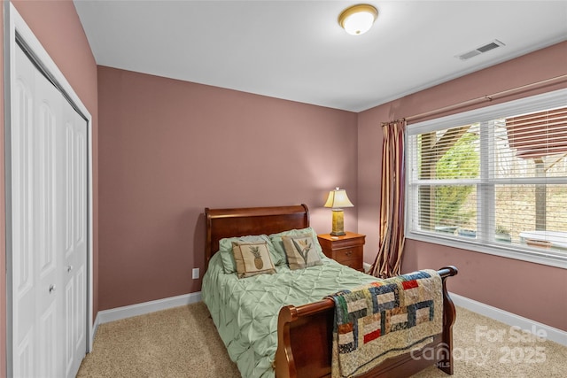 bedroom featuring visible vents, a closet, baseboards, and carpet flooring