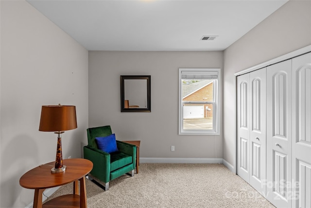 living area with light carpet, visible vents, and baseboards