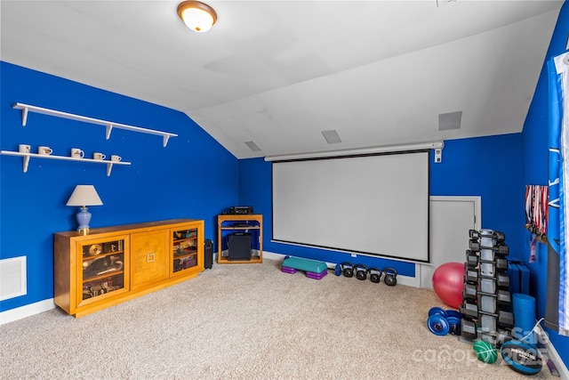 carpeted cinema with lofted ceiling, visible vents, and baseboards