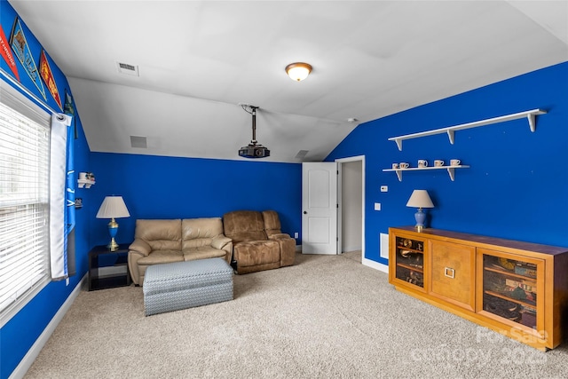 living room featuring carpet floors, baseboards, visible vents, and vaulted ceiling