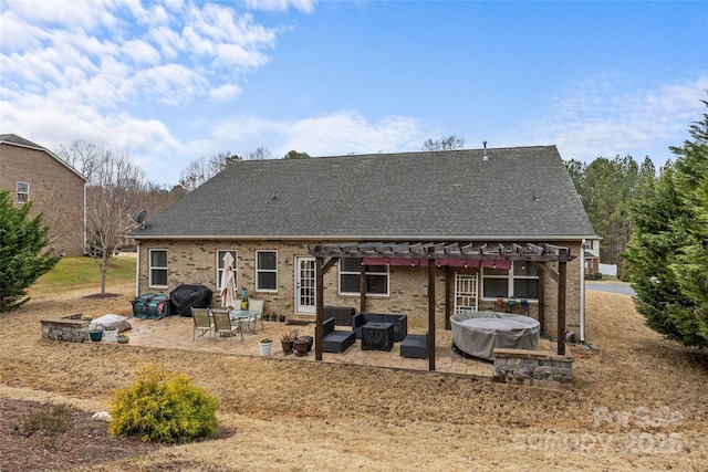 rear view of property with a shingled roof, a patio area, an outdoor living space, a pergola, and brick siding