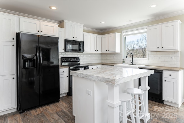 kitchen with light countertops, white cabinets, a sink, and black appliances