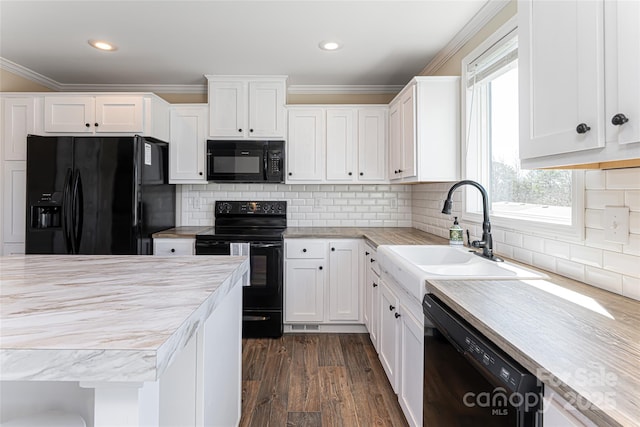 kitchen with light countertops, crown molding, black appliances, white cabinetry, and a sink