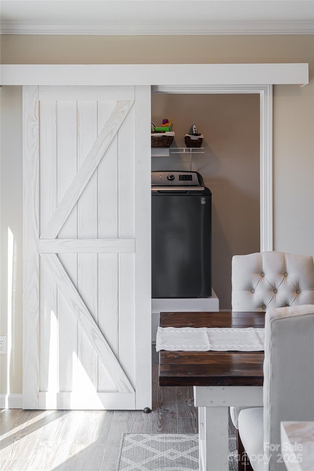 interior space with washer / clothes dryer, crown molding, and wood finished floors