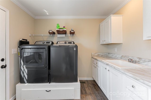 laundry room featuring cabinet space, dark wood-style floors, washing machine and clothes dryer, crown molding, and a sink