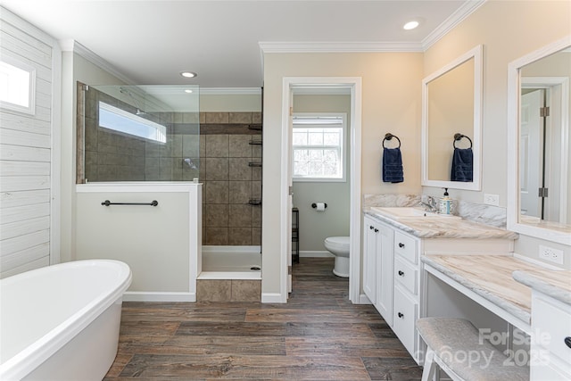 full bathroom featuring ornamental molding, a shower stall, toilet, and wood finished floors