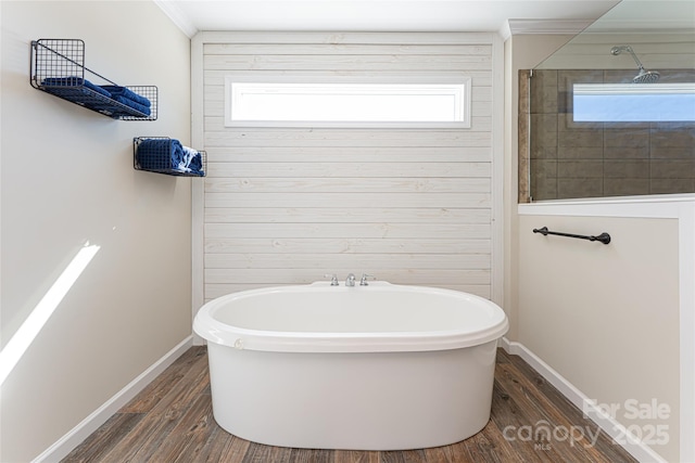 bathroom featuring a freestanding tub, crown molding, a wealth of natural light, and wood finished floors