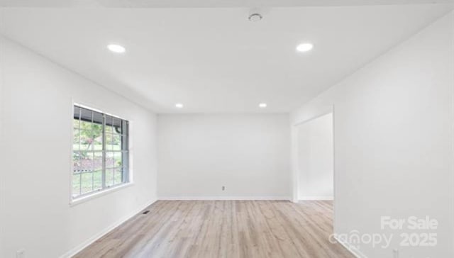 spare room featuring light wood-style floors, recessed lighting, and baseboards