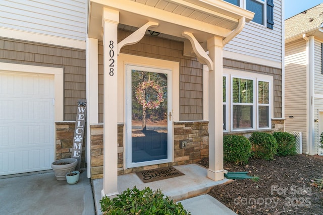 property entrance featuring stone siding and an attached garage