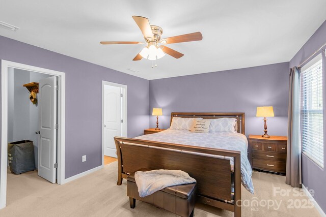 bedroom featuring baseboards, visible vents, ceiling fan, and light colored carpet