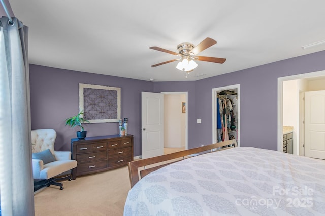 bedroom featuring a closet, light colored carpet, ceiling fan, and a spacious closet