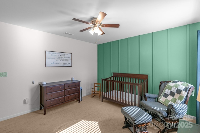 bedroom with light carpet, ceiling fan, visible vents, and baseboards