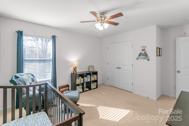 bedroom with a closet, carpet flooring, a ceiling fan, and baseboards