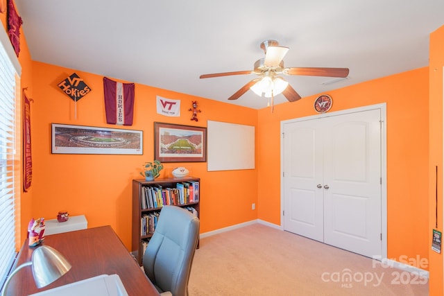 office area with a ceiling fan, carpet flooring, and baseboards