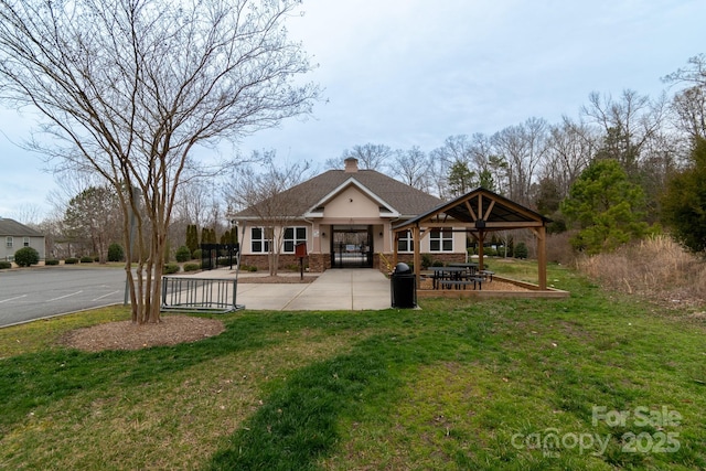 view of front of home featuring roof with shingles, brick siding, a chimney, and a front lawn