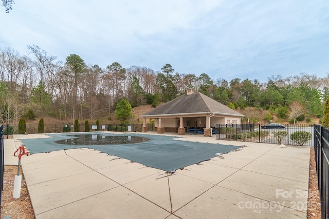 community pool featuring a patio area and fence