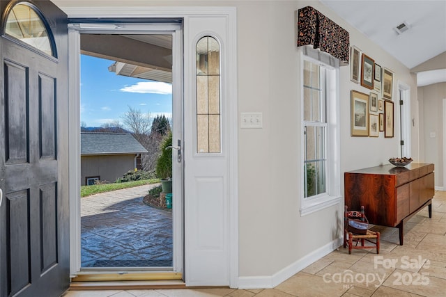 doorway featuring lofted ceiling, baseboards, and visible vents