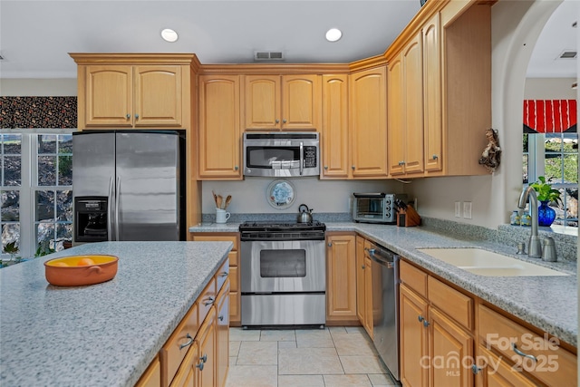 kitchen with visible vents, light stone countertops, stainless steel appliances, a sink, and recessed lighting