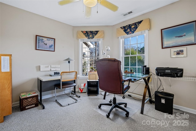 office space featuring ceiling fan, plenty of natural light, visible vents, and baseboards