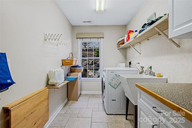 laundry area featuring baseboards, visible vents, cabinet space, and washing machine and clothes dryer