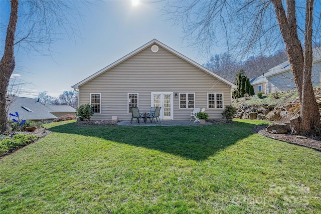 rear view of property featuring a lawn and a patio area