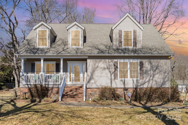 cape cod home with a porch, crawl space, a lawn, and a shingled roof