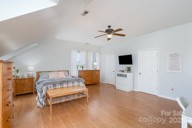 bedroom with lofted ceiling, visible vents, light wood-style floors, ceiling fan, and baseboards