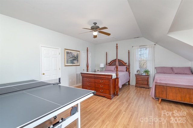 bedroom featuring light wood finished floors, vaulted ceiling, and a ceiling fan