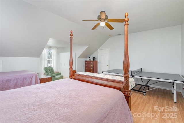 bedroom with a ceiling fan, lofted ceiling, visible vents, and light wood-style flooring