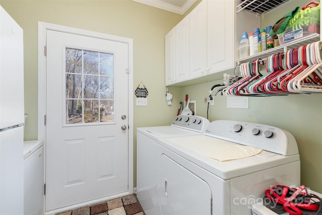 laundry room featuring washer and dryer, cabinet space, and crown molding