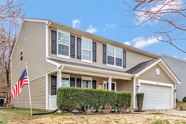 traditional-style home with covered porch, concrete driveway, and an attached garage