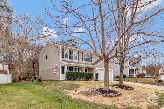 traditional-style house featuring an attached garage, driveway, a front yard, and fence