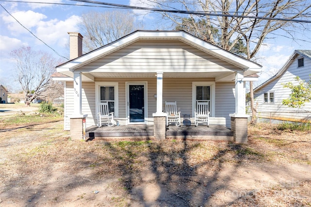 bungalow-style home with a chimney and a porch