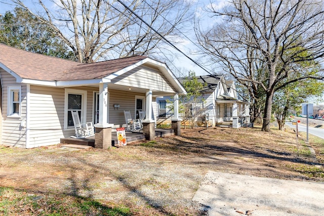 bungalow-style house with a shingled roof and covered porch