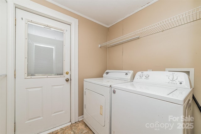 washroom featuring laundry area, washing machine and dryer, and crown molding