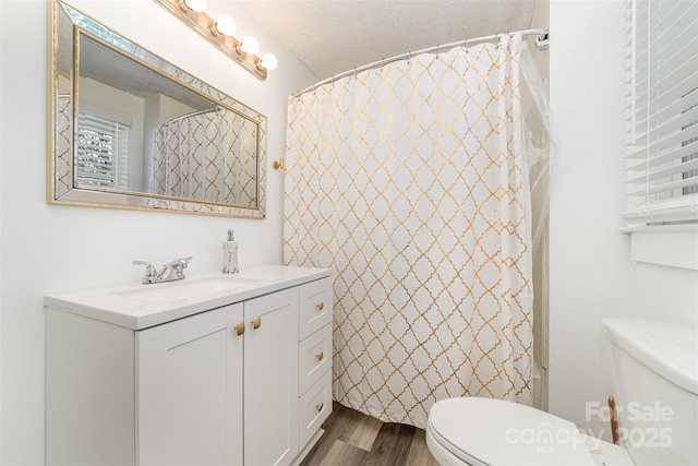 bathroom featuring toilet, curtained shower, wood finished floors, and vanity