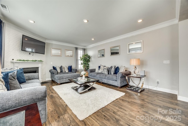 living area featuring a fireplace, visible vents, baseboards, ornamental molding, and dark wood-style floors