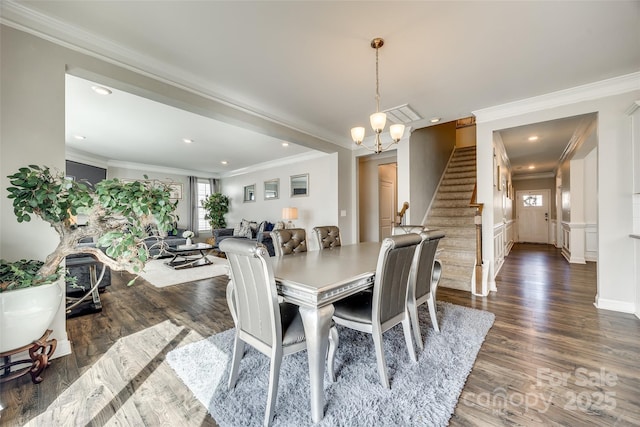 dining area with ornamental molding, dark wood-style flooring, an inviting chandelier, stairs, and recessed lighting