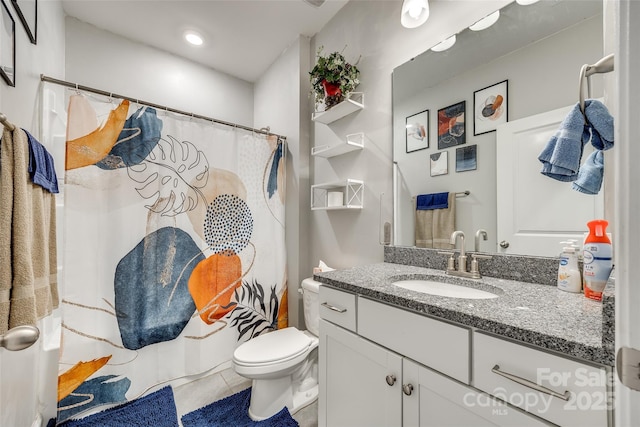 bathroom featuring tile patterned flooring, vanity, and toilet